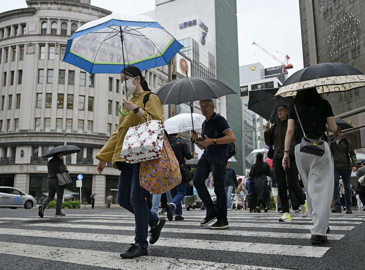 東京銀座街頭撐傘過馬路的行人