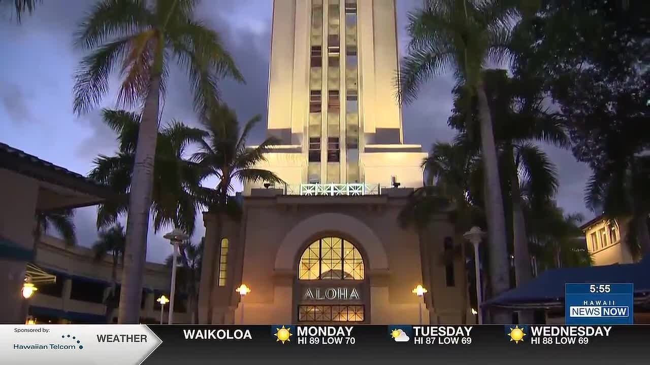 夜色中的檀香山阿囉哈塔，白色塔身被燈光照亮，四周有椰子樹