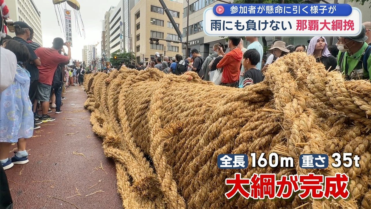 沖繩那霸大拔河祭上,大批參加者在雨中合力拉起巨大的稻草繩