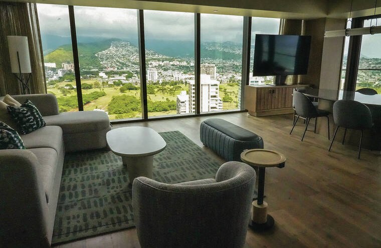 Ka Haku 套房客廳,有沙發、餐桌與大片落地窗,窗外是綠色山景與市區