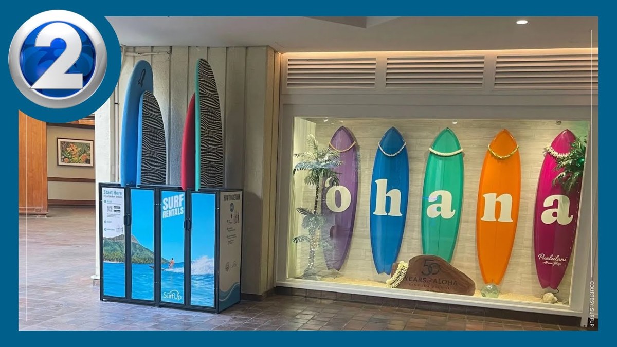 威基基凱悅飯店內的 SurfPod 自助衝浪板租借站,旁邊牆上掛著寫有 ohana 字樣的彩色衝浪板