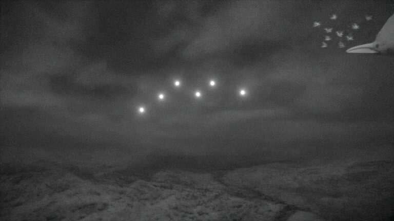 五角大廈公開 UFO 影片:6 顆小球時速 770 公里在中東上空急轉彎?研究者分析:可能只是一群鳥 灰白色調的紅外線畫面風格天空中,六個發亮的小圓點成群飛過,角落隱約顯示其實是一小群拍著翅膀的鳥的插畫