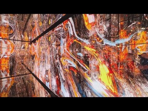 鏡面與巨大LED螢幕包圍的空間裡,滿是流動的橘紅色抽象光影