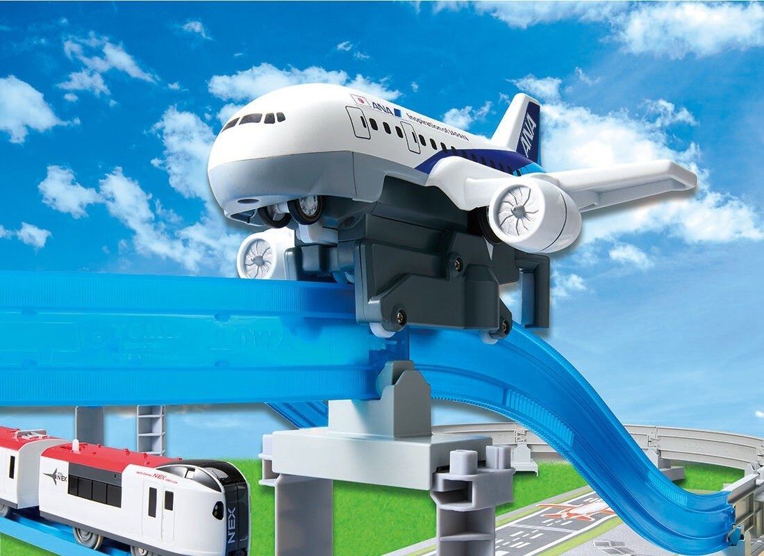 白色旅客機玩具沿著藍色透明軌道往上爬升,下方有火車玩具