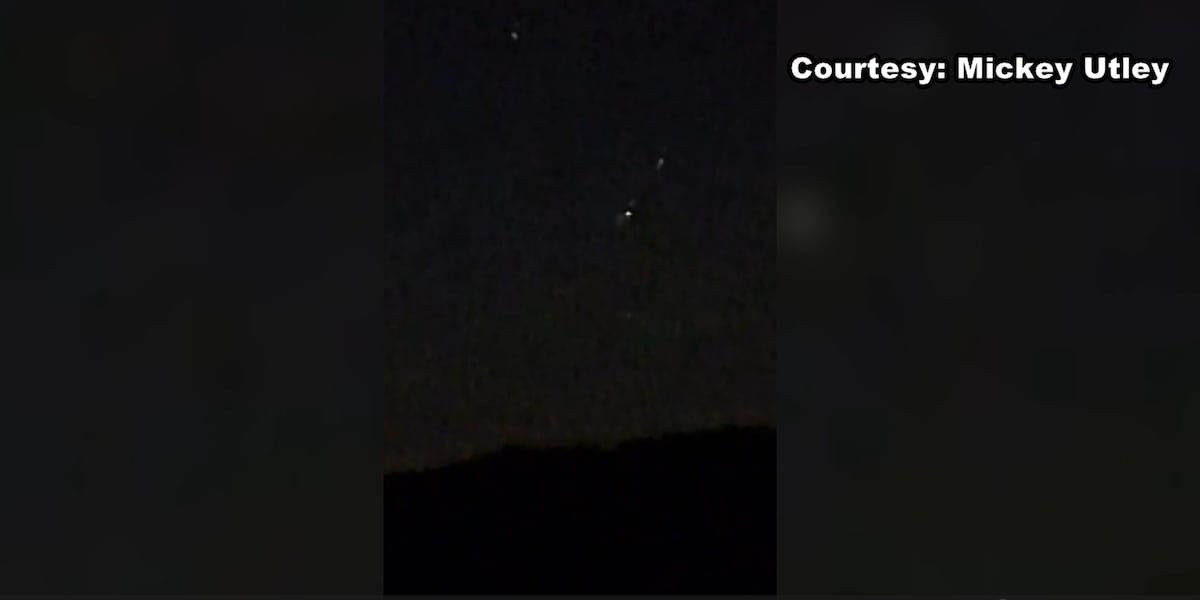 漆黑夜空中幾個排成一列的小亮點，下方是山丘的黑色輪廓