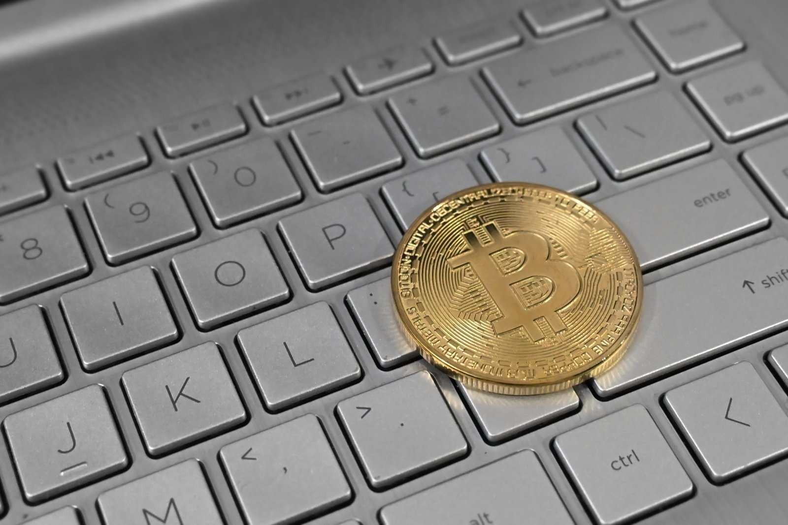 一枚金色比特幣紀念幣放在筆電鍵盤上